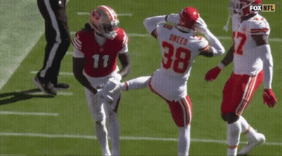 A Football Player With The Number 38 On His Jersey Is Kicking Another Player . GIF