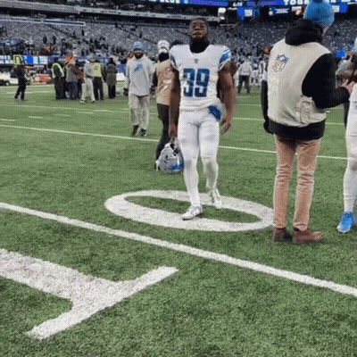 A Football Player With The Number 39 On His Jersey Walks On The Field GIF