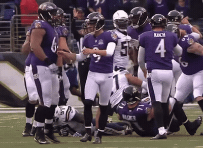 A Football Player With The Number 4 On His Jersey Is Surrounded By His Teammates GIF