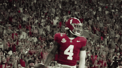 A Football Player With The Number 4 On His Jersey Stands In Front Of A Crowd GIF