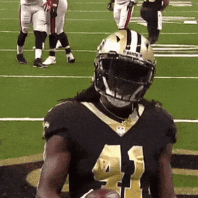 A Football Player With The Number 41 On His Jersey Is Holding A Football GIF