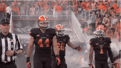 A Football Player With The Number 44 On His Jersey Walks With Two Other Players GIF