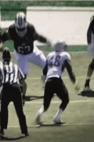 A Football Player With The Number 46 On His Jersey Is Being Tackled GIF