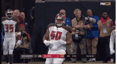 A Football Player With The Number 50 On His Jersey Stands On The Field GIF