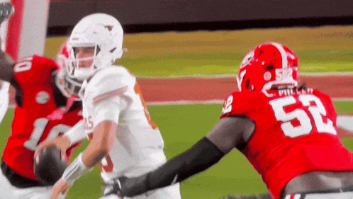 A Football Player With The Number 52 On His Jersey Is Being Tackled By Another Player GIF