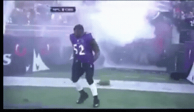 A Football Player With The Number 52 On His Jersey Is Dancing On The Field GIF