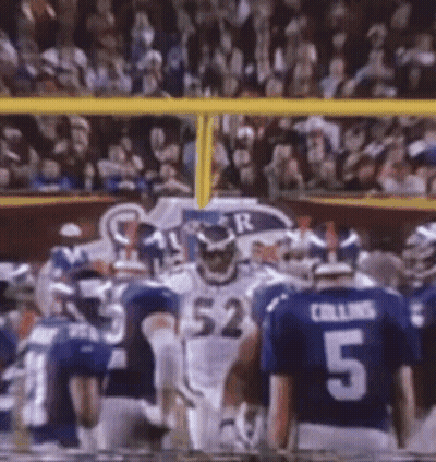 A Football Player With The Number 52 On His Jersey Stands In Front Of A Crowd GIF