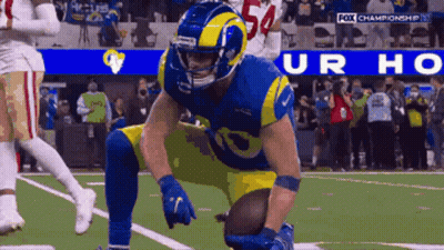 A Football Player With The Number 54 On His Helmet Kneeling On The Field GIF