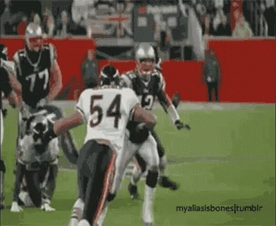 A Football Player With The Number 54 On His Jersey Is Running On The Field . GIF