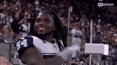 A Football Player With The Number 54 On His Jersey Stands In Front Of A Crowd GIF