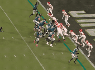 A Football Player With The Number 65 On His Jersey Is Being Tackled By Another Player GIF
