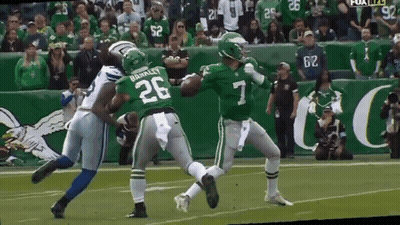 A Football Player With The Number 7 On His Jersey Is Being Tackled By Another Player GIF