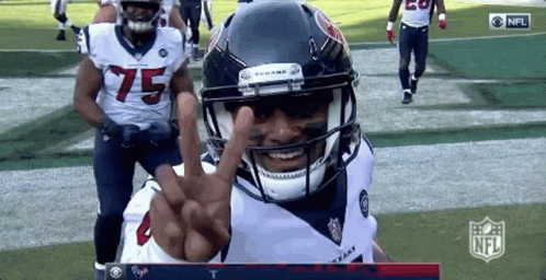 A Football Player With The Number 75 On His Jersey Is Giving A Peace Sign GIF