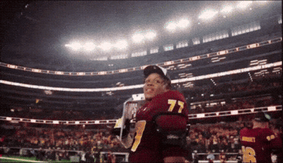 A Football Player With The Number 77 On The Back Of His Shirt GIF