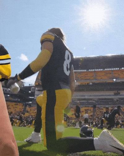 A Football Player With The Number 8 On His Back Is Kneeling On The Field GIF
