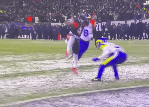 A Football Player With The Number 8 On His Jersey Is Being Tackled GIF