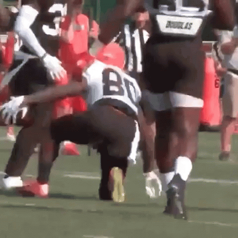 A Football Player With The Number 80 On His Jersey Is Being Tackled GIF