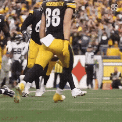 A Football Player With The Number 88 On His Jersey Is Running On A Field . GIF