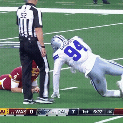 A Football Player With The Number 94 On His Jersey Is Being Tackled By A Referee GIF