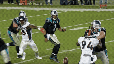 A Football Player With The Number 94 On His Jersey Is Being Tackled GIF