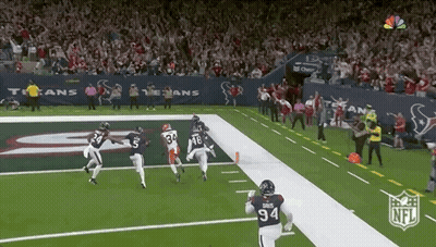A Football Player With The Number 94 On His Jersey Is Running On The Field During A Game . GIF