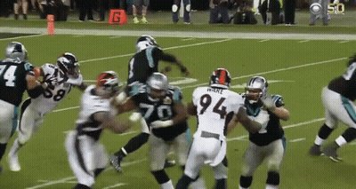 A Football Player With The Number 94 On His Jersey Is Surrounded By Other Players GIF