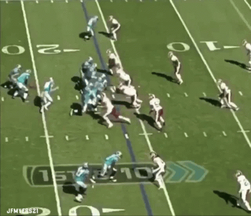 A Football Player With The Number 98 On His Jersey Is Being Tackled GIF