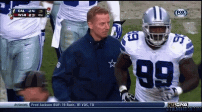 A Football Player With The Number 99 On His Jersey Stands Next To A Coach GIF