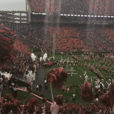 A Football Stadium With A Marching Band And Cheerleaders On The Field GIF