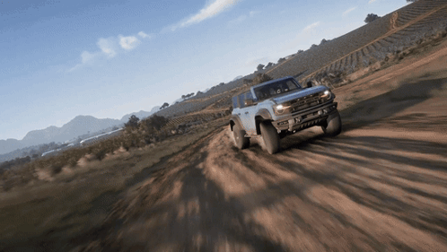 A Ford Bronco Is Driving Down A Dirt Road GIF