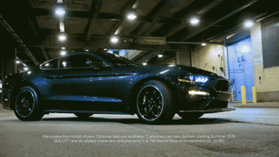 A Ford Mustang Is Parked In Front Of A Warehouse GIF