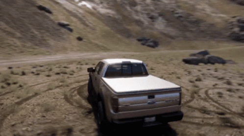 A Ford Truck Driving Down A Dirt Road GIF