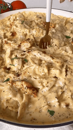 A Fork Is In A Bowl Of Pasta With Chicken And Cheese GIF