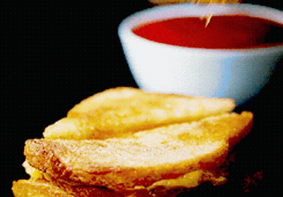 A French Toast Sandwich Next To A Small Bowl Of Sauce GIF