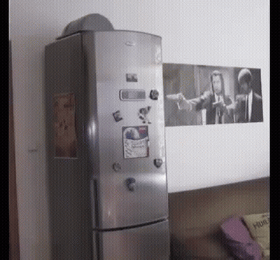 A Fridge With A Picture Of Pulp Fiction On The Wall Behind It GIF