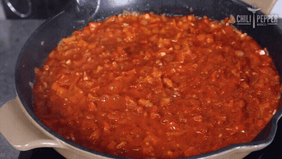 A Frying Pan Filled With Tomato Sauce With The Words Chili Pepper On The Bottom GIF