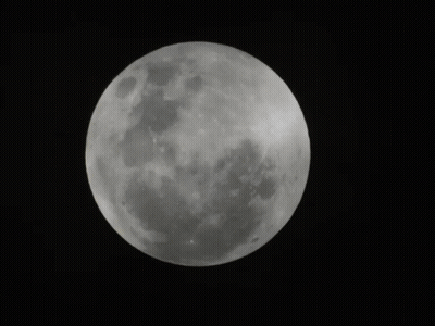 A Full Moon Is Visible In The Dark Sky GIF