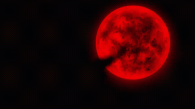 A Full Red Moon Is Shining Brightly In The Dark GIF