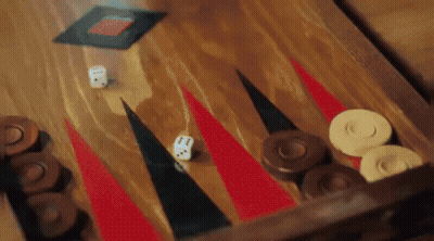 A Game Of Backgammon Is Being Played On A Wooden Board . GIF