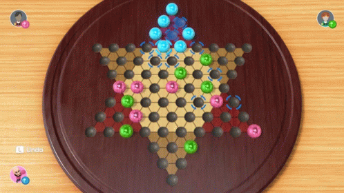 A Game Of Chinese Checkers Is On A Wooden Board GIF