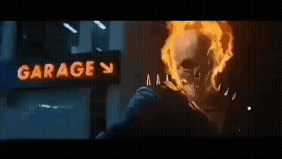 A Ghost Rider Is Riding A Motorcycle In Front Of A Garage . GIF