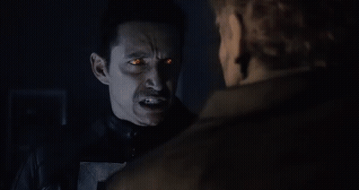 A Ghost Rider With Flames Coming Out Of His Head Is Standing Next To A Man . GIF