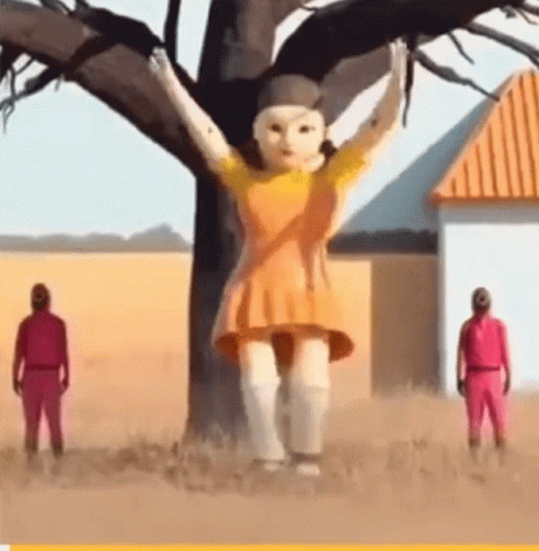 A Giant Doll Is Standing In Front Of A Tree . GIF