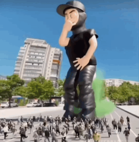 A Giant Inflatable Figure Of A Man Standing In A Crowd Of People GIF