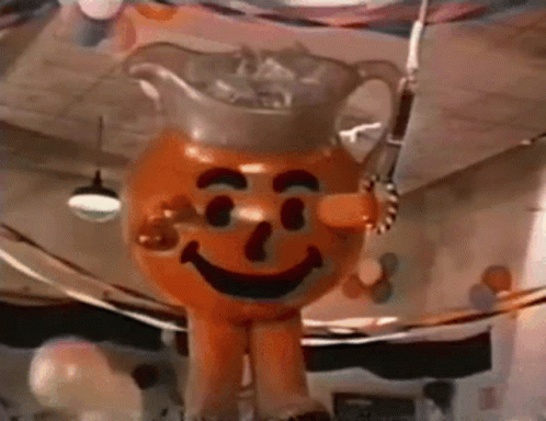 A Giant Inflatable Orange Man With A Pitcher Of Iced Tea On His Head . GIF