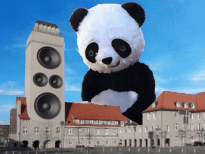 A Giant Panda Bear Is Standing In Front Of A Large Speaker GIF