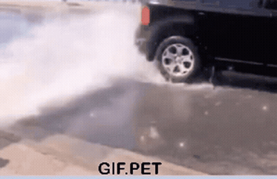 A Gif Of A Car Driving Through A Puddle With Gif.pet Written Below It GIF