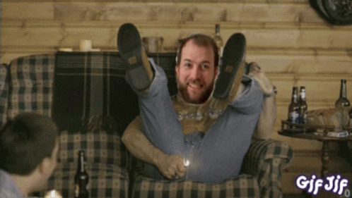 A Gif Of A Man Sitting On A Couch With His Legs Up And The Word Gif On The Bottom GIF