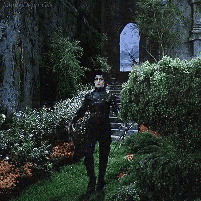 A Gif Of Johnny Depp Standing In A Garden GIF