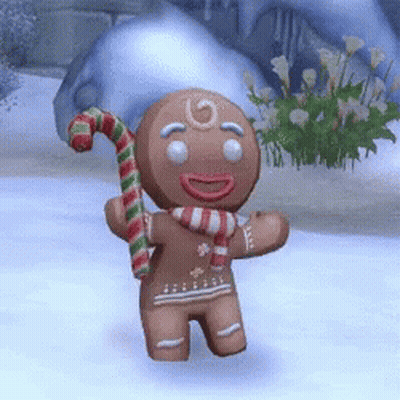 A Gingerbread Man Is Holding A Candy Cane And Wearing A Scarf GIF